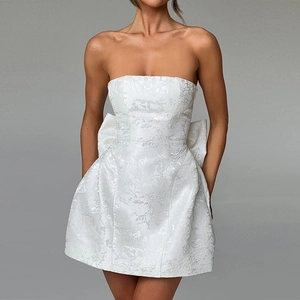 Détail d'une mini robe bustier blanche avec jacquard floral et grand nœud élégant