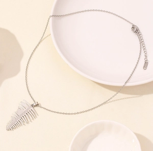 Macro shot of silver leaf pendant necklace with fine cable chain and lobster clasp