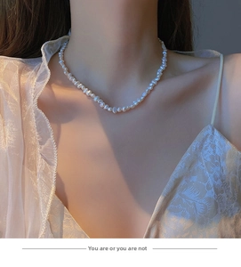 Elegant baroque freshwater pearl necklace worn by a model in warm atmospheric lighting