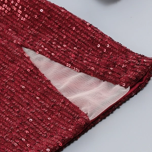 Détail de paillettes rouge foncé et de mesh sur une robe de soirée sexy à manches longues