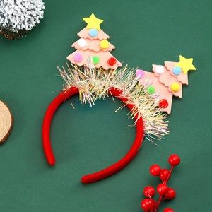 Red Christmas tree headband with sequins and pom poms on festive pine needle backdrop
