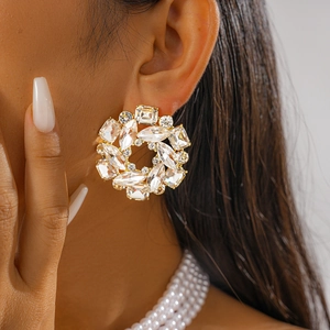 Close-up of golden wreath stud earrings with marquise crystals and elegant pearls
