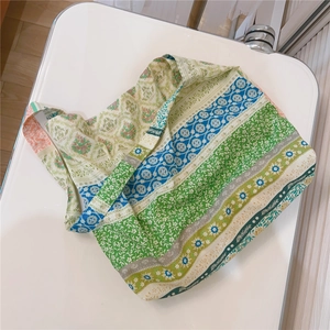 Detailed top view of a colorful floral patchwork cotton tote bag on a white surface