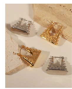 Detail of geometric fan-shaped earrings with dotted texture in gold and silver finish