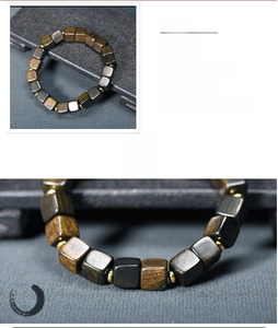 Macro detail of handmade square natural wood beads with golden spacers and organic texture
