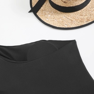 Detailed close-up of black one-shoulder swimsuit featuring built-in bra pads and ribbed texture