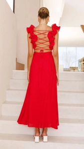 Dettaglio dell'abito lungo in chiffon rosso con spalline incrociate sulla schiena e volant