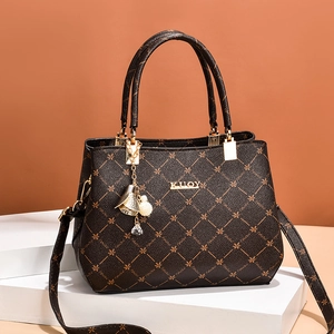 Brown faux leather handbag with gold KUQY hardware on a white display stand