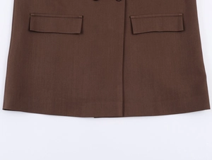 Detailansicht der gewebten Stoffstruktur und Klappentaschen an einem braunen Blazer