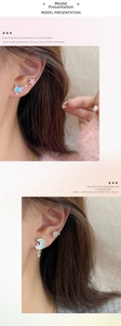 Detailed close-up of laser aurora butterfly and crescent moon stud earrings on model