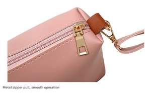 Detail of pink PU leather coin purse showing smooth gold metal zipper and stitching