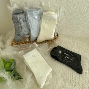 Détail de chaussettes en coton en cinq couleurs dans des sacs zippés de marque