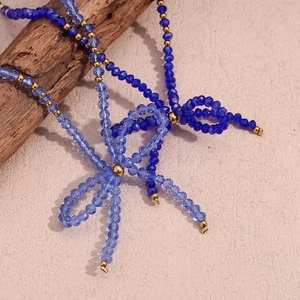 Detailed shot of blue faceted crystal beads and gold metal accents in a bow necklace