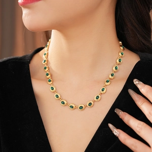 Détail d'un collier vintage doré avec pierre ovale verte sur le cou d'un mannequin