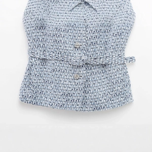 Blue and white tweed vest for women with textured fabric, metal buttons and a matching belt
