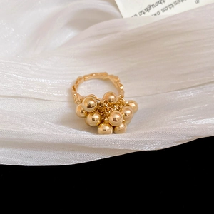 Detailed macro view of irregular gold ball ring on elegant white pleated satin fabric