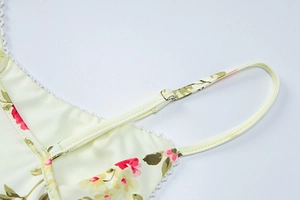 Detail view of pink floral print dress with white lace trim and adjustable shoulder straps