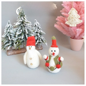 Handcrafted wool felt snowman ornaments with Christmas tree decorations on a grey background