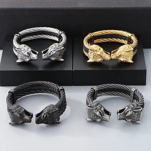 Detail of twisted wire steel bracelets with wolf head carvings in four metallic colors