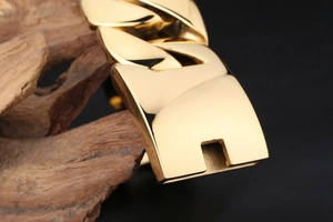 Macro shot of 18k gold plated 31mm thick Cuban link chain with secure buckle on wood