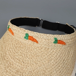 Detail eines Raffia-Sonnenhuts mit Karottenstickerei und verstellbarem schwarzem Gummiband