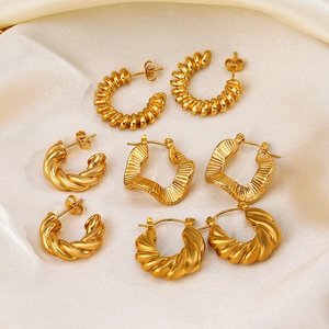 Set of vintage French geometric gold stainless steel earrings on white silk background
