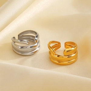 Polished 18K gold and silver chunky wrap rings on elegant champagne satin background