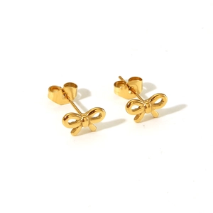 Detail of polished gold bow stud earrings with secure butterfly backing and shiny finish