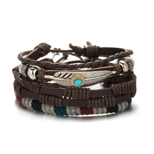 Detail of vintage multilayer leather bracelets with feather charm and turquoise stone