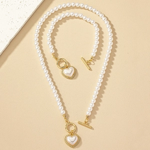 Detail view of pearl necklace and bracelet set with rhinestone heart pendant and OT buckle