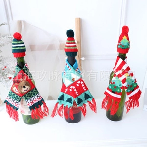 Detail of mini knitted Christmas wine bottle hats and scarves with reindeer embroidery