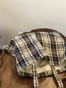 Detail of blue diamond quilted cotton tote bag with classic plaid pattern on wood table