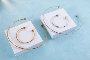 Detailed view of gold and silver torque necklaces and bracelets with sliding beads on display