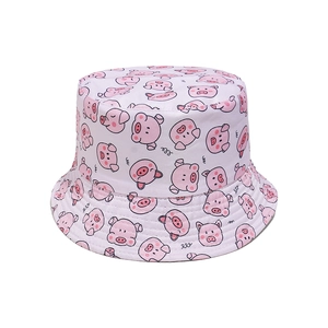 Close-up of cotton twill fabric and cute cartoon pig prints on a pink bucket hat