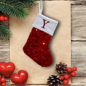 Close-up of red sequined Christmas stocking with white cuff featuring embroidered letter Y