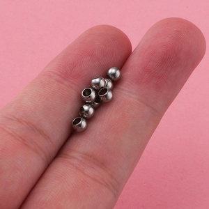 Macro shot showing 3x4mm silver hollow stainless steel beads on finger for scale