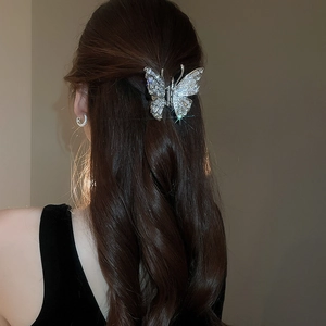 Close-up of a butterfly hair claw clip with silver metal and sparkling rhinestones