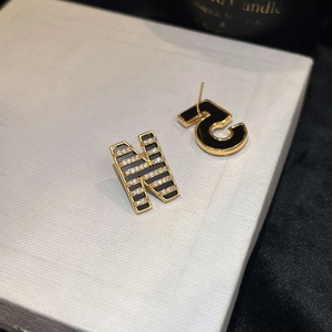 Detailed view of 18K gold-plated asymmetrical earrings with N and R letters and zircons