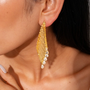 Gros plan de boucles d'oreilles en maille dorée 18K avec zircons gouttes d'eau