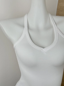 Close-up of white ribbed knit halter top featuring a V-neckline on a female mannequin