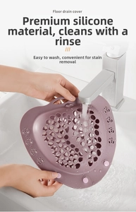 Close-up of purple silicone floor drain cover being rinsed under faucet in a sink