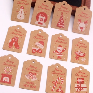 Detail of kraft paper Christmas gift tags with Merry Christmas text on wooden tray