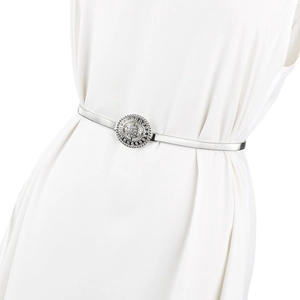 Gros plan de la ceinture élastique argentée avec boucle ronde en strass sur une robe