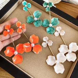 Three pairs of floral drop earrings with pearls in green orange and white colors