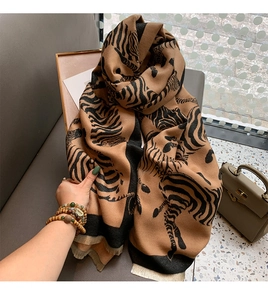 Detail of bohemian orange shawl with black zebra pattern and soft fringe edges