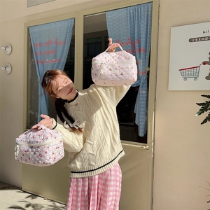 Detail of quilted cotton toiletry bags with floral and bear prints featuring sturdy handles