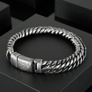 Close-up of vintage industrial mesh stainless steel bracelet with buckle clasp on black stand