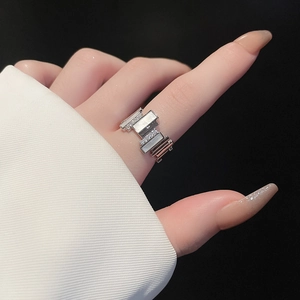 Detail of silver geometric ring with square mother-of-pearl and zircon inlay on finger