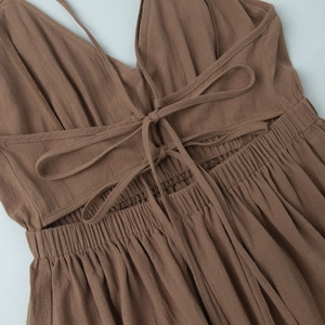 Détail du dos nu à lacets croisés et taille élastiquée sur robe longue marron