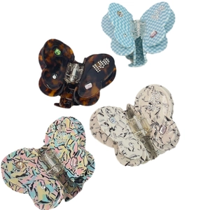 Elegant set of four butterfly acetate hair claws with rhinestones on white background
